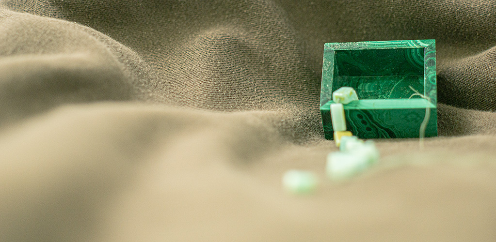 Malachite box open with jade beads falling out of it