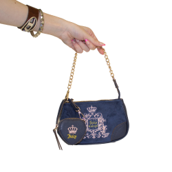 A small blue Juicy Couture purse that is velveteen and blue, embroidered with a pink Juicy Couture logo. A smaller heart coin purse with the word Juicy and a crown is attatched to the gold chain purse handle.