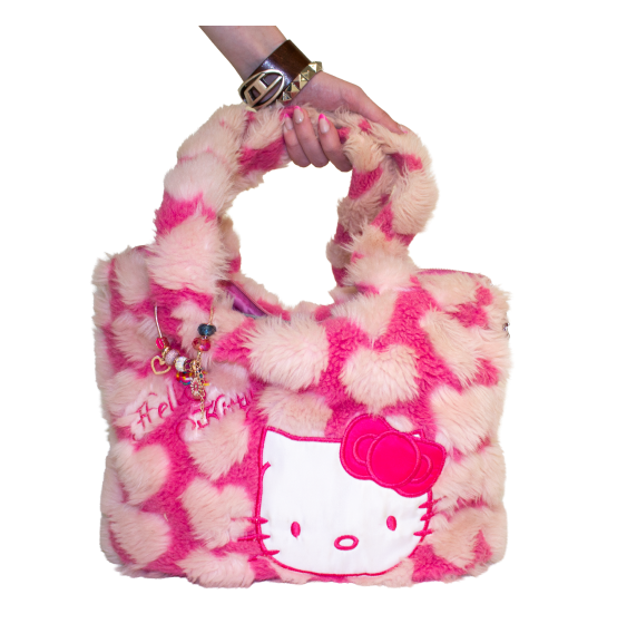A hand holding a fluffy hot pink/light pink bag with a heart pattern and a large Hello Kitty patch embroidered on the front of it.