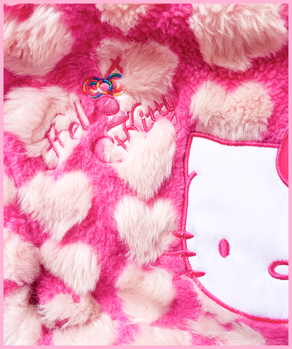 Up close detial shot of Charlize showing the pink fluffy texure and colorful embroidered detail that says Hello Kitty.