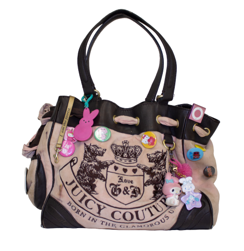 A Juicy Couture handbag with a bold crest logo, adorned with colorful pins and charms, including cartoon figures and embroidered dogs on the front.