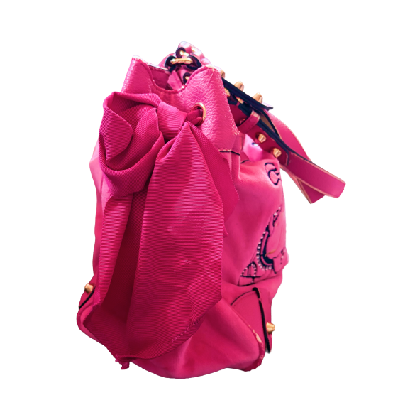 A side view of large hot pink juicy couture purse with large pink bow laced to the side.