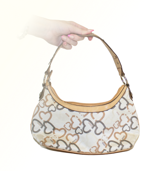 An XOXO brand tan purse, with a gray and brown heart pattern on it, silver hardware.