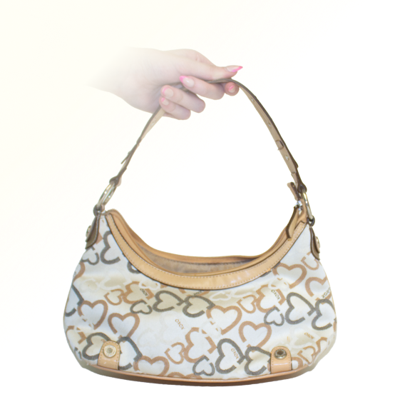 An XOXO brand tan purse, with a gray and brown heart pattern on it, silver hardware.