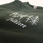 Angled dark green sweatshirt that reads Folklore.