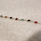 Bracelet with multicolored gems representing different Taylor Swift Albums.