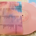 Vinyl cover that showcases the songs on specific vinyl with a light pink vinyl.