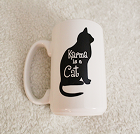 A white mug with a black cat that reads Karma is a Cat.
