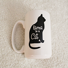 A white mug with a black cat that reads Karma is a Cat.