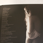 Inside page of The Tortured Poets Department vinyl that shows a photo of Taylor Swift alongside a poem that she wrote for her album.