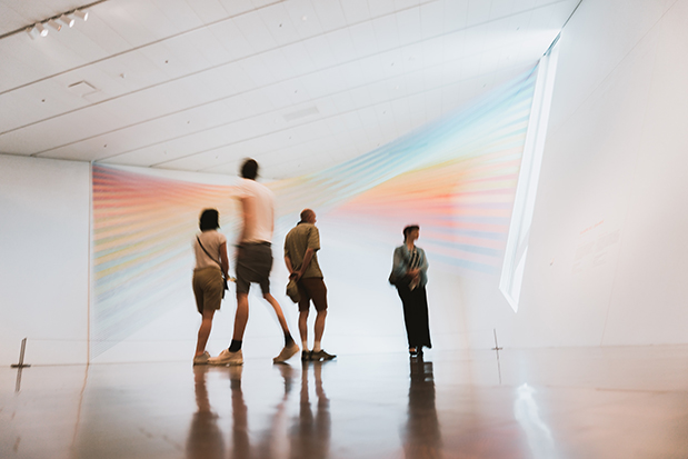 An inside look of an art gallery in Velaris filled with people